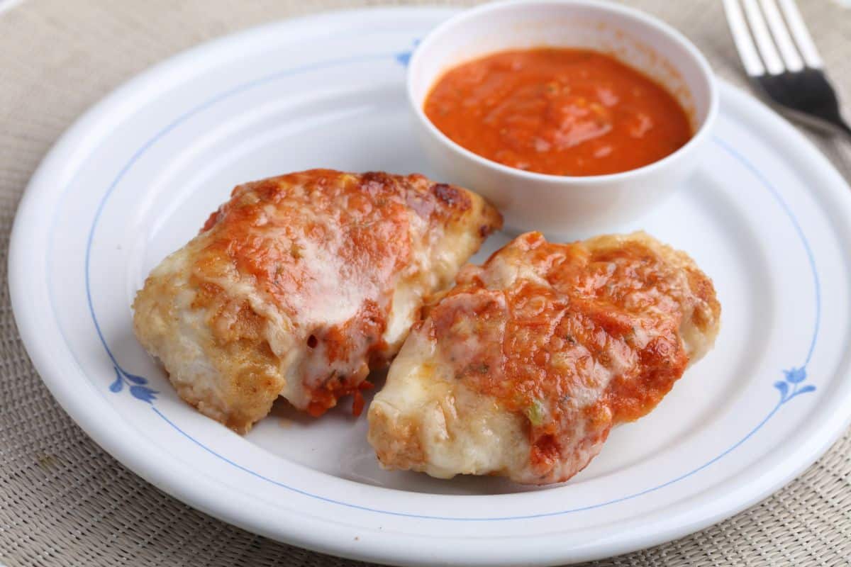 Frango a parmegiana: Com molho de tomate e muito queijo!