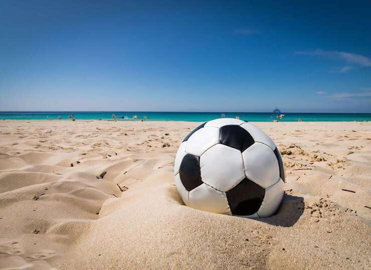 uma bola de futebol esta na areia de uma praia 888757 1190